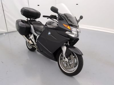 une moto noire garée dans une pièce aux murs blancs