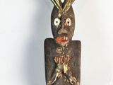 a wooden sculpture of a man with a large head