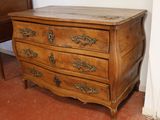 a wooden chest of drawers in the corner of a room