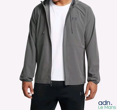 un homme en chemise blanche et pantalon noir, debout devant un fond blanc