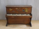 un petit piano en bois posé sur un parquet en bois massif