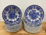 plusieurs assiettes bleues et blanches empilées les unes sur les autres sur une table en bois