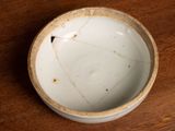 a small white bowl sitting on a wooden table