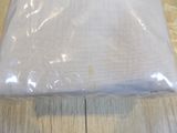a white pillow on a wooden floor covered in plastic