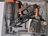 a box with a stapler, stapler, nail gun, and other tools in it