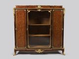 une armoire ancienne en bois, avec des portes vitrées et des garnitures dorées