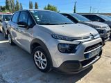 une Citroën argentée garée sur un parking à côté d'autres voitures