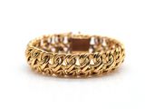 a close up of a gold bracelet on a white background