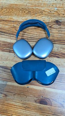 two pairs of headphones and a pair of glasses on a wooden floor