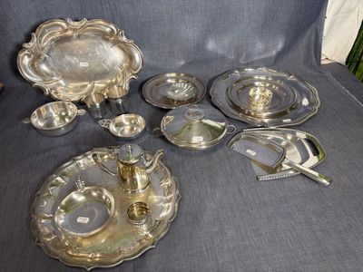 un assortiment d'objets en métal argenté et d'argenterie posé sur une chaise bleue