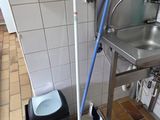 a mop and a bucket on the floor next to a sink
