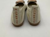 a pair of white shoes with brown trims on them
