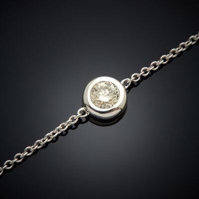un bracelet en diamants suspendu à une chaîne sur fond noir