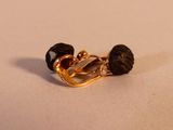 une broche plaquée or ornée de pierres noires