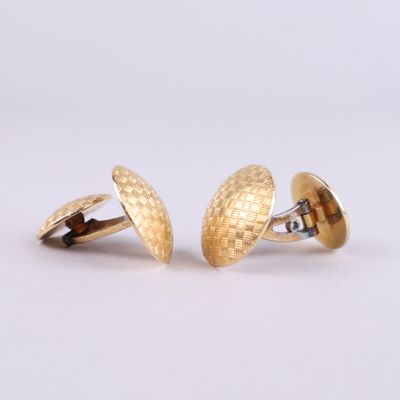 deux paires de boutons de manchette en or sur fond blanc
