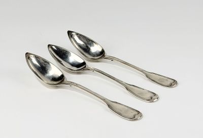 quatre cuillères en argent empilées les unes sur les autres sur une surface blanche