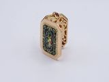 une image représentant une bague en or ornée d'un motif noir et vert
