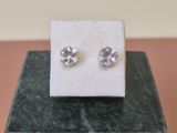 a pair of earrings sitting on top of a marble block