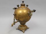 an antique brass teapot on a stand with a spout