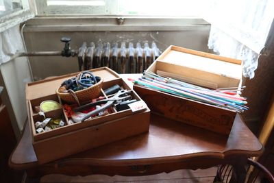 deux boîtes en bois posées sur une table, contenant des ciseaux et d'autres objets
