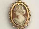 un pendentif plaqué or représente le profil d'une femme