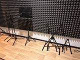 three microphone stands in front of a wall of sound foam