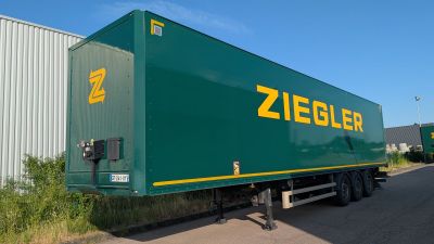 a green semi trailer parked on the side of the road