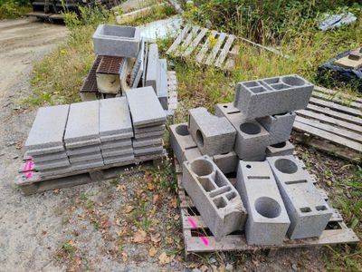 un tas de parpaings posé par terre à côté d'un tas de palettes