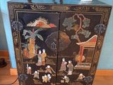 a black cabinet with a horse on top of it