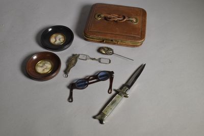 une petite boîte contenant des ciseaux, une montre de poche et une paire de ciseaux