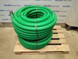 a green hose sitting on top of a pallet next to a wall