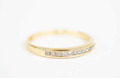 a yellow gold ring with diamonds on a white background