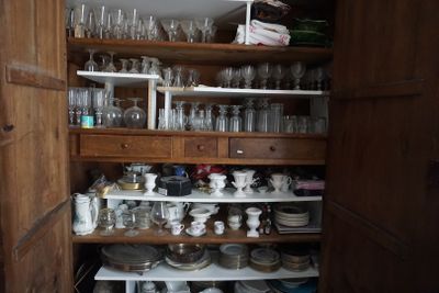 un placard rempli de vaisselle et de verres dans la cuisine