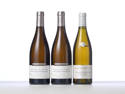three bottles of wine are lined up on a table