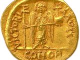 a close up of a gold coin with an image of a man holding a sword