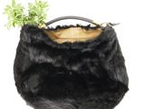 black fur purse with a plant in it on a white background