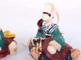 two figurines of a man and a woman riding on a camel