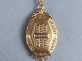 a gold brooch with a cross on it on a blue surface