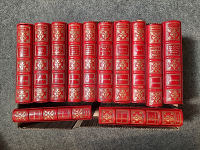 Plusieurs livres rouges sont empilés les uns sur les autres sur une surface grise