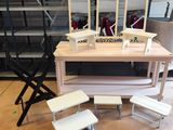 une table avec un miroir et des tabourets dans une pièce
