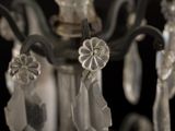 close up of a crystal chandelier hanging from a black ceiling
