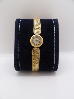 an image of a gold wrist watch with a blue velvet case