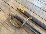 a very old sword on the floor next to a smaller sword