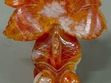 a glass figurine of an orange flower on a table