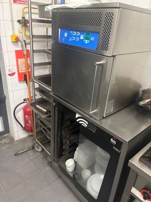 un four argenté installé dans une cuisine, à côté d'une cuisinière