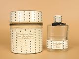 candle in a glass jar next to a small glass jar with a lid