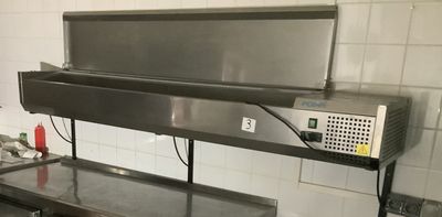 un grand plan de travail en métal dans une cuisine, sur lequel est posé un micro-ondes