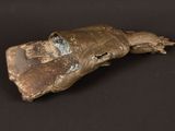 an image of a bronze object on a black surface