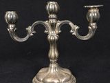 an antique silver plated candelab with two candles on a stand