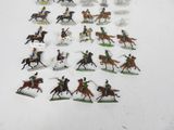 a lot of figurines of people riding horses and horses